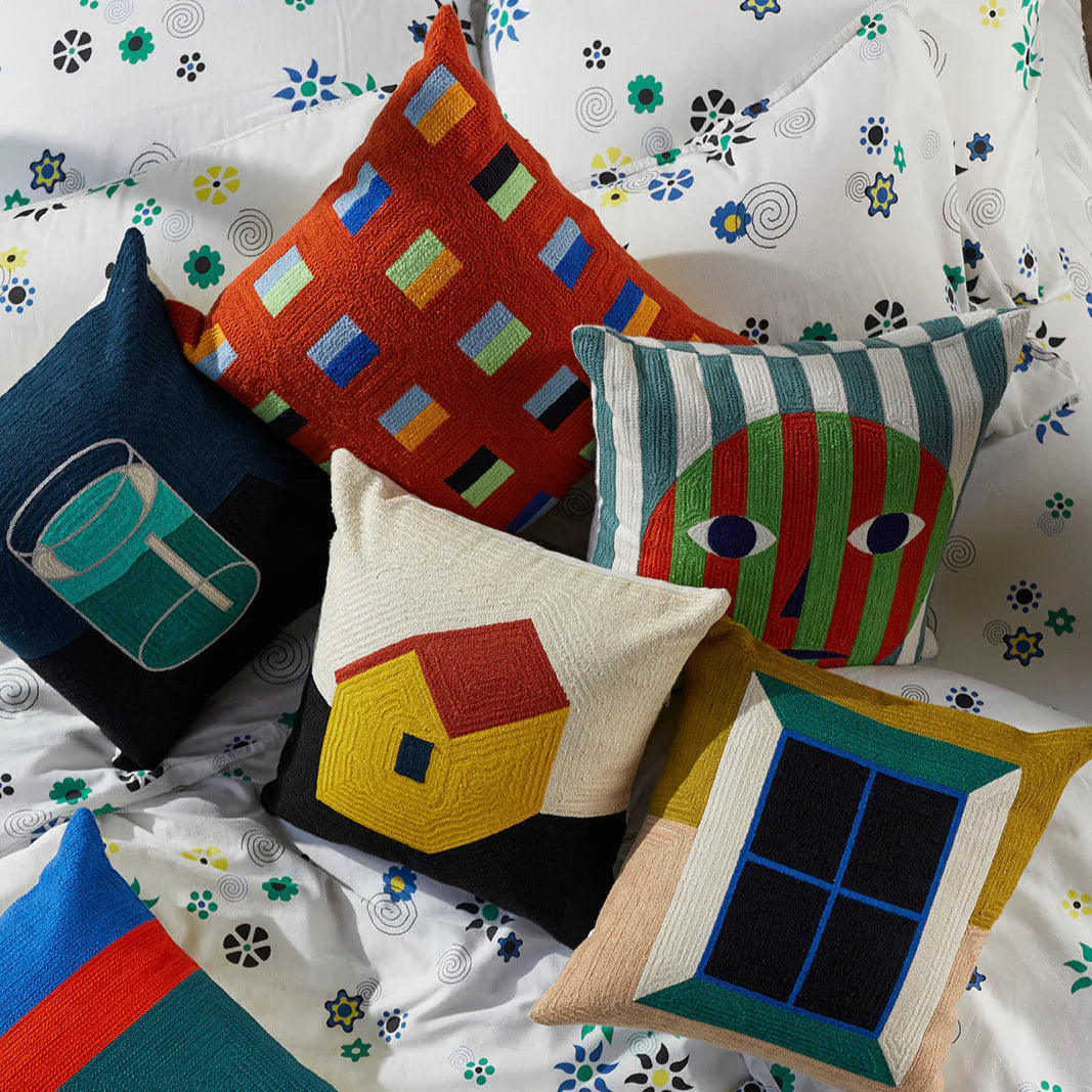 Colorful pillows on a floral-patterned bedspread