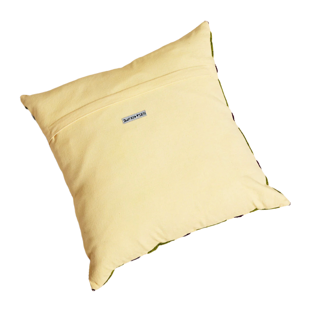 Yellow pillow with a brand label on a white background